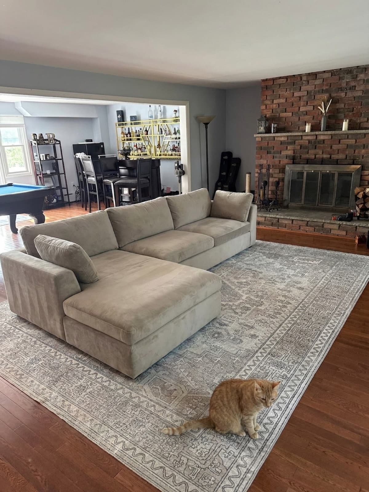 AI concept render of the Harmony sectional in distressed velvet facing the brick fireplace