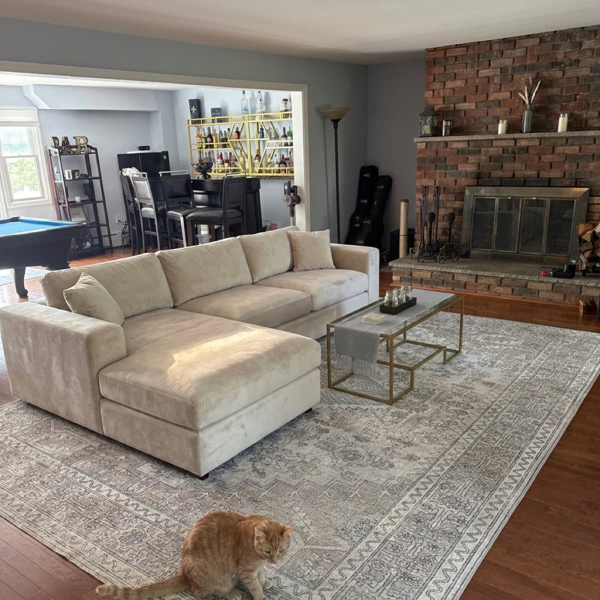 AI concept render of the sectional across the full rug with the bar and billiards room behind